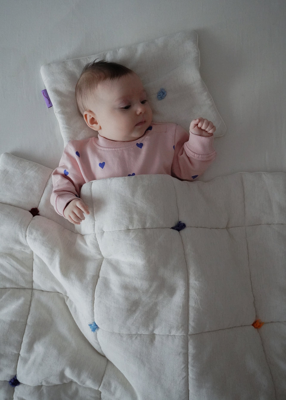 Niemowlęcy kocyk Endless Hugs z bawełny, kremowy z kolorowymi akcentami, idealny do łóżeczka.