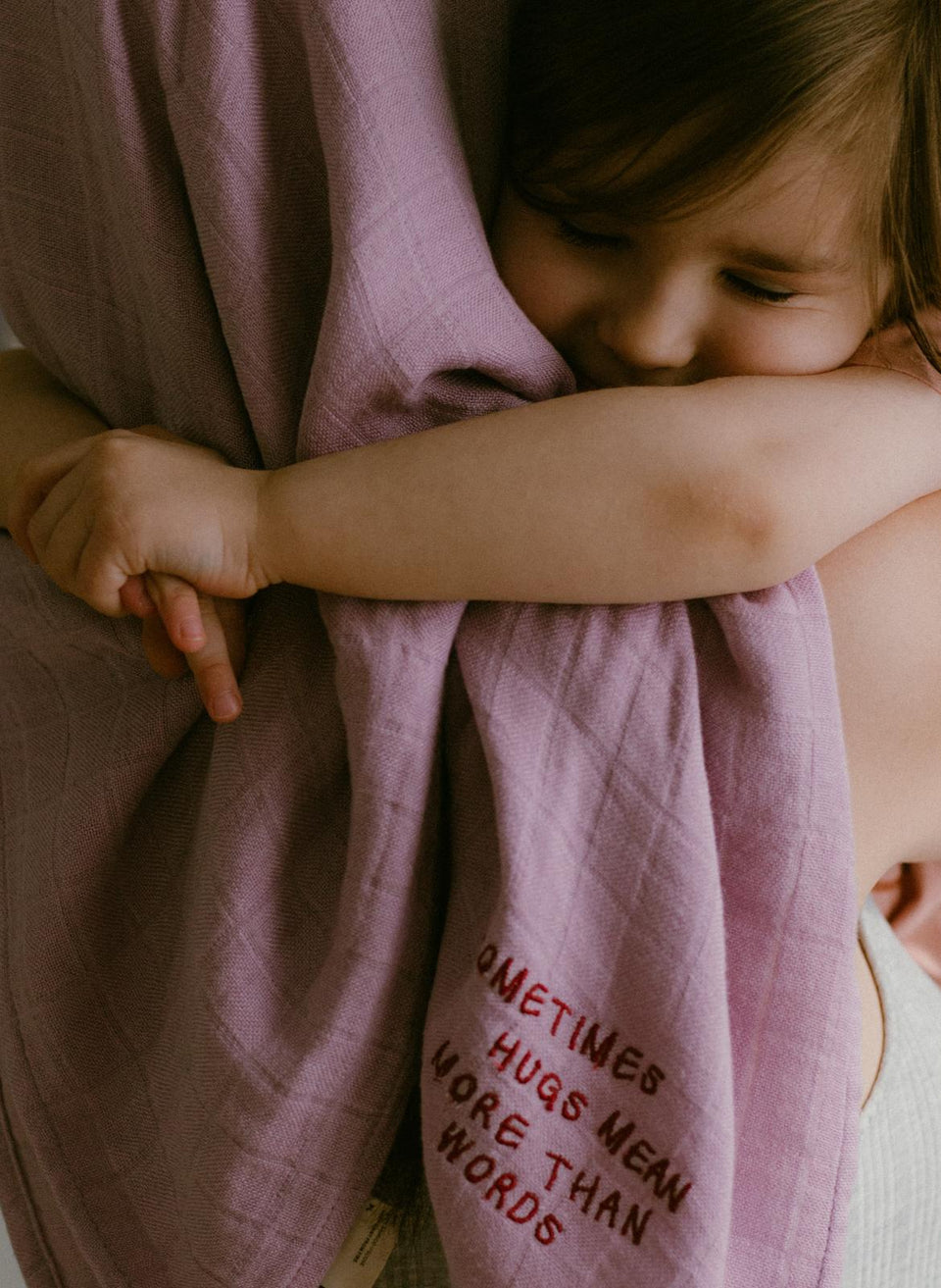 Bawełniany kocyk Endless Hugs w kolorze liliowym z haftem tekstowym.
