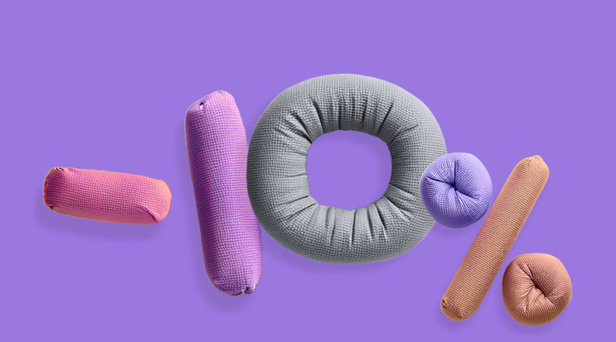 Weiche Kissen geformt in die Form „-10%“ auf violettem Hintergrund.