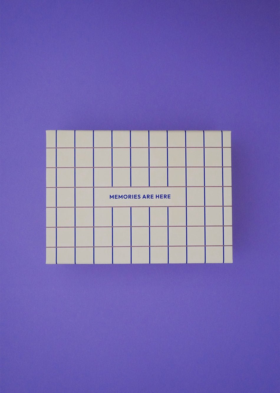 Pudełko pamięci Endless Hugs – Pudełko wspomnień dla niemowląt w kratę - Butter ma niebieską kratkę i napis „MEMORIES ARE Here” na wieczku, dzięki czemu jest idealnym prezentem dla rodziców i jest prezentowane na jednolitym fioletowym tle.