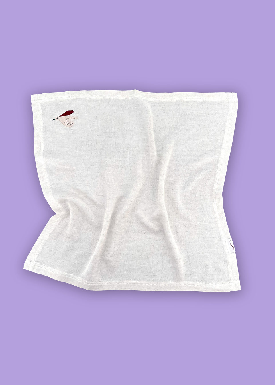 Hipoalergiczne piękno muślinowych chust bambusowych Endless Hugs, PIELUSZKI MUŚLINOWE Z BAMBUSA - DWUPAK 60x60 CM/ PTASZKI, uwydatnione jest małym haftowanym piórkiem na lawendowym tle.
