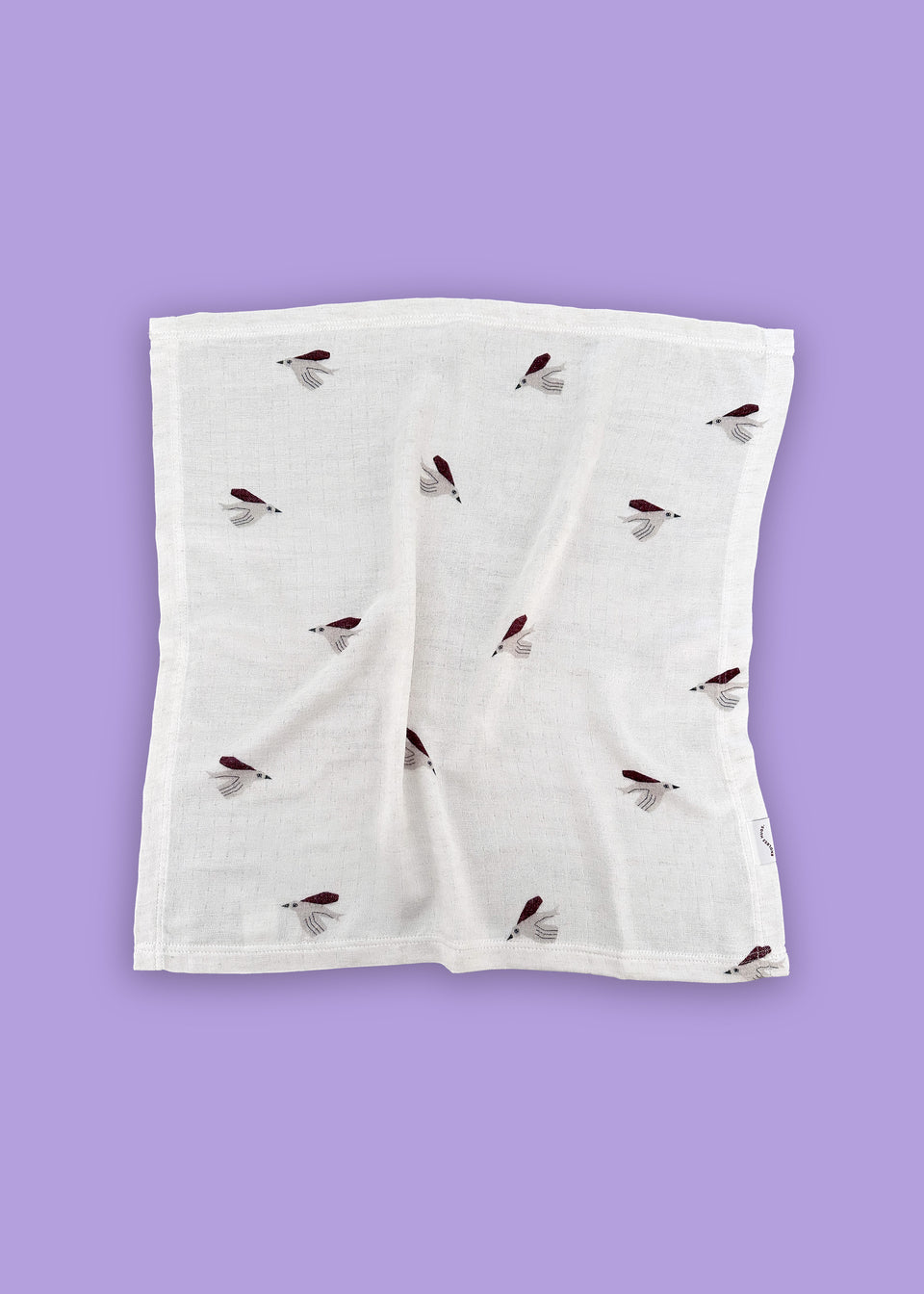 PIELUSZKI MUŚLINOWE Z BAMBUSA - DWUPAK 60x60 CM / PTASZKI od Endless Hugs wyróżniają się haftowanym wzorem brązowych i czarnych much na białym materiale na fioletowym tle, co podkreśla ich hipoalergiczne właściwości.